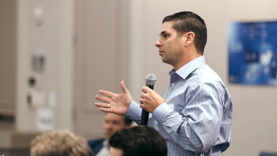 Male Oxy employee speaking at a microphone in meeting