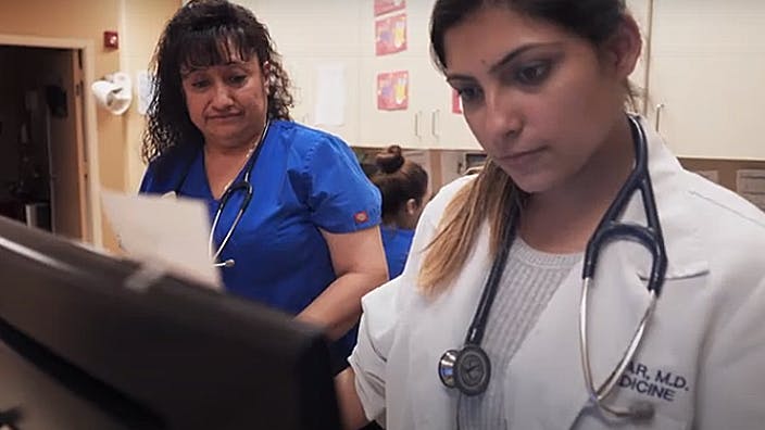Female doctor and nurse looking at monitor